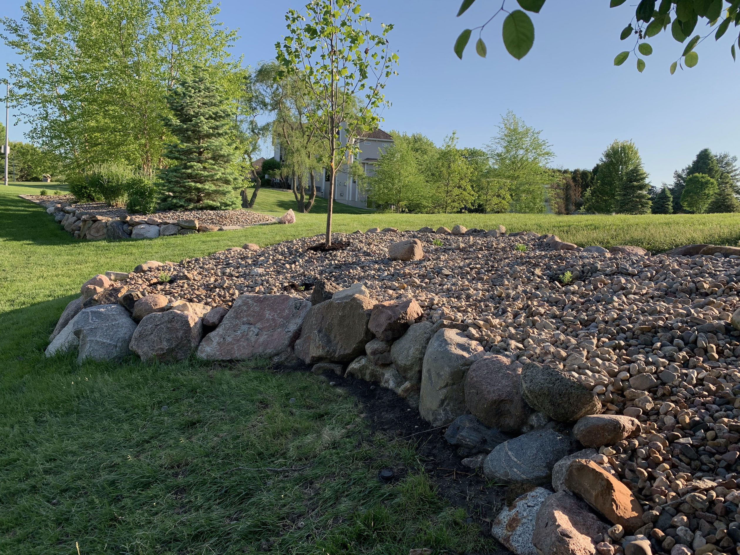 stone-lined-flower-bed-with-trees