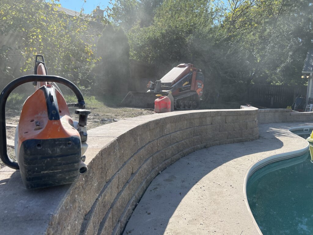 landscaping-equipment-behind-finished-retaining-walls-near-pool