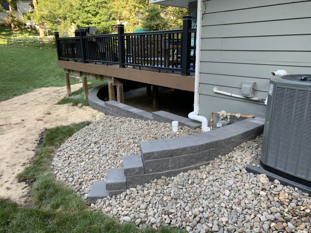 stone-walls-wrap-around-house-under-deck-with-stone