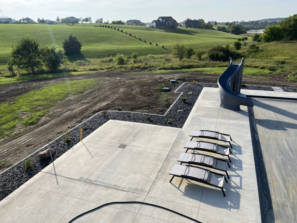 backyard-sunning-concrete-patio-slide-with-pool